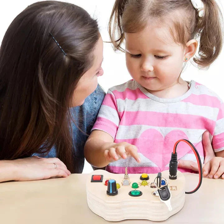 Une jeune fille et une femme regardent une boîte à outils électronique pour enfants posée sur la table.